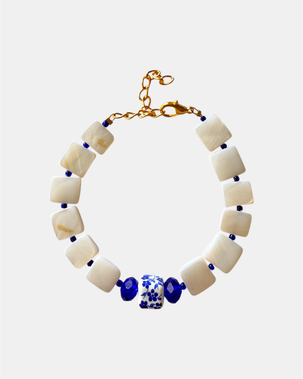 Beige bracelet featuring mother-of-pearl and a blue ceramic charm for a natural and elegant style