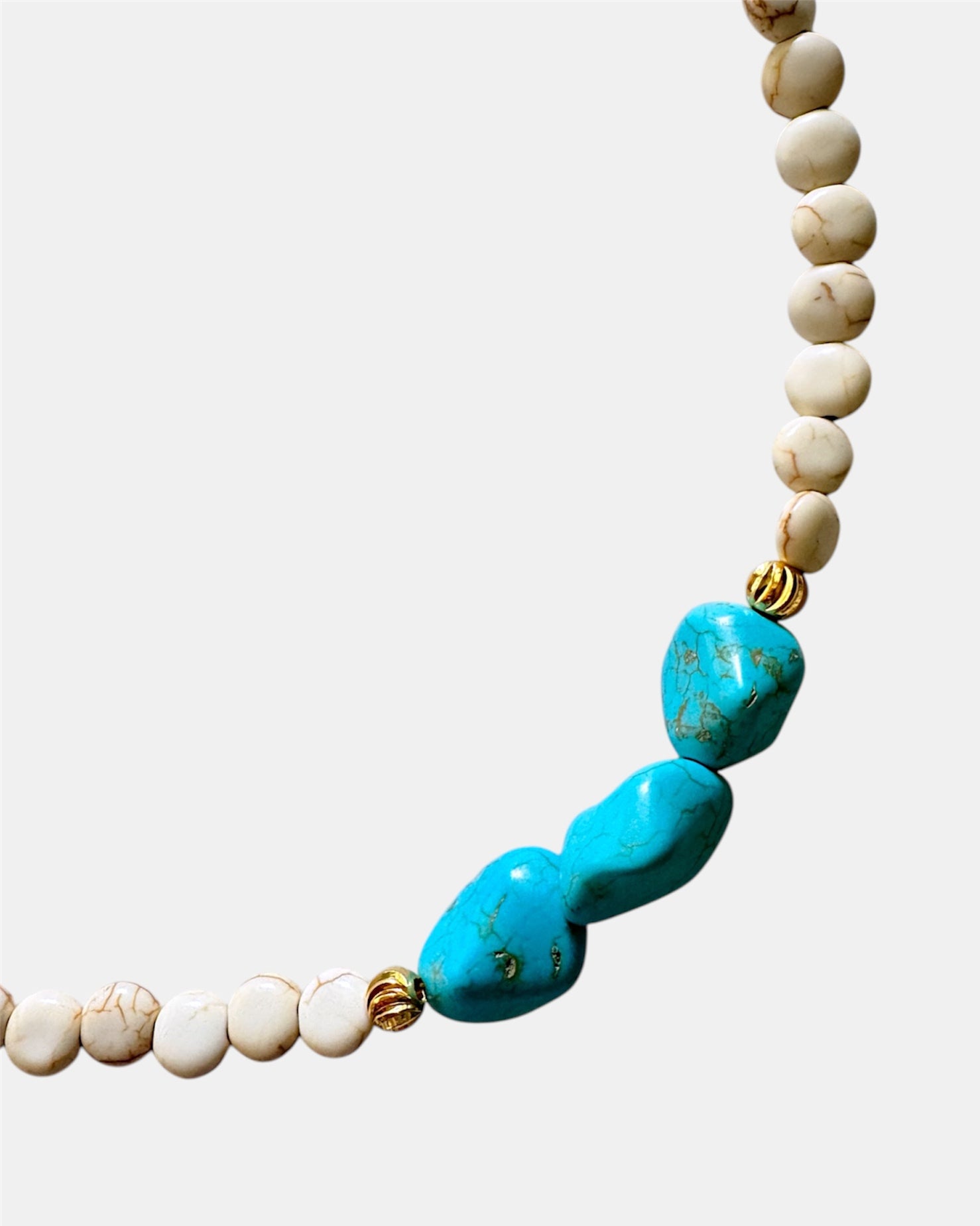 Beige necklace featuring turquoise stones for a natural, earthy style