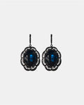 Black dangling earrings featuring a blue gemstone, elegant jewelry design on a plain background.