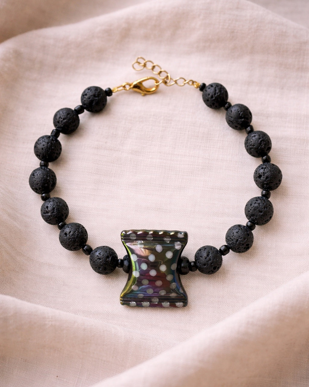 Black lava bead bracelet with a ceramic candy charm