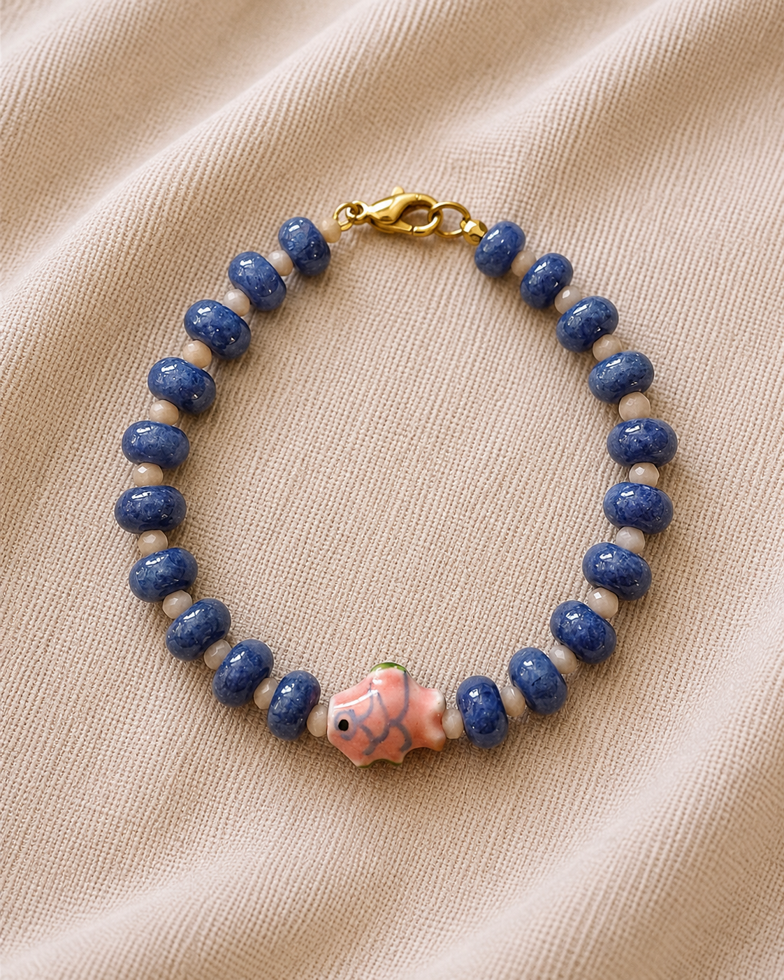 Blue beaded bracelet with fish charm in nautical elegant style