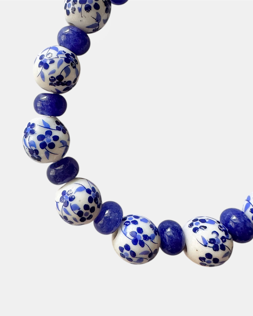 Bracelet with blue and white beads on a light gray background
