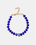 Blue bracelet featuring glass beads and a ceramic charm for a stylish, artistic look