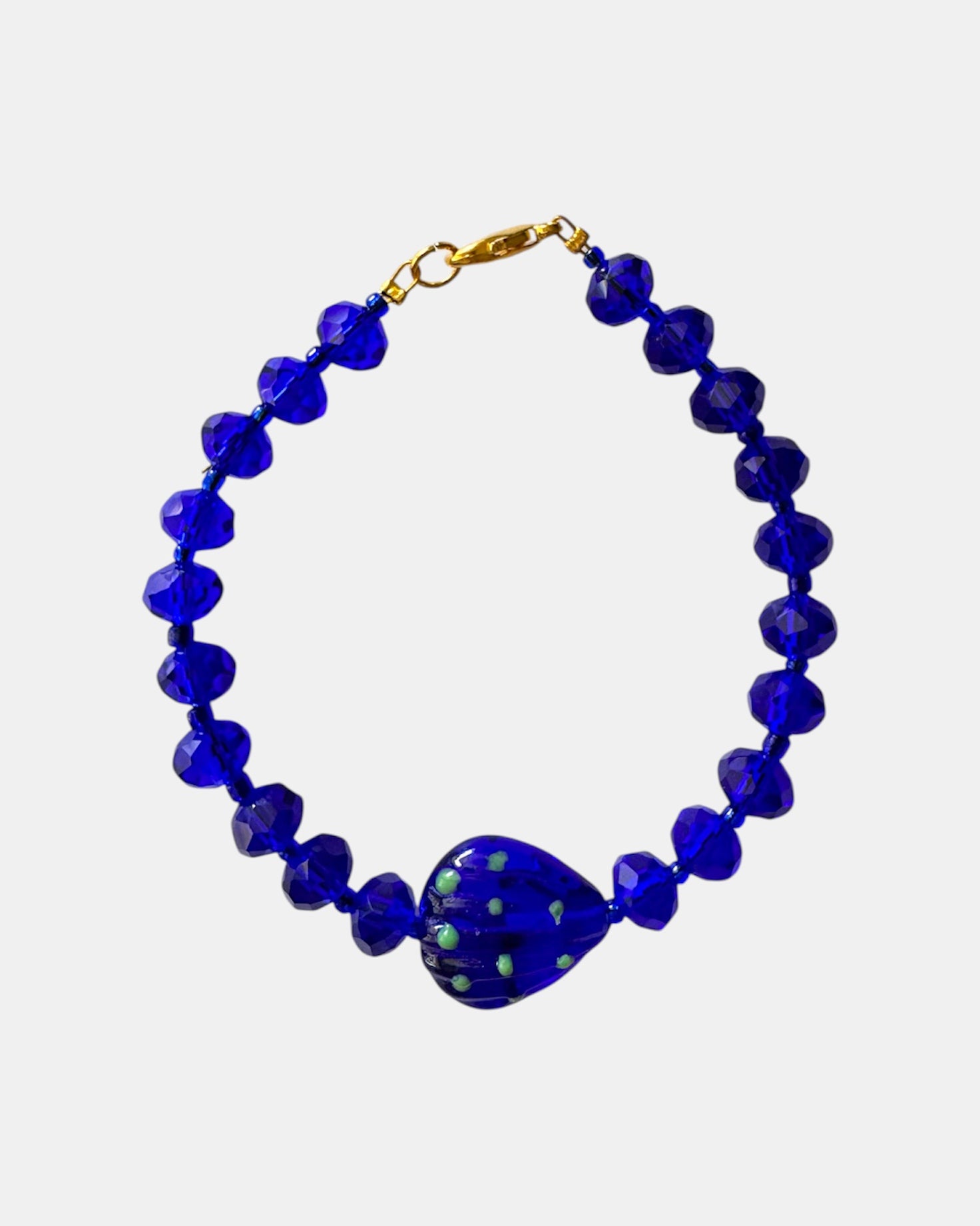 Blue bracelet decorated with glass beads and a small seashell charm for a beach-inspired look