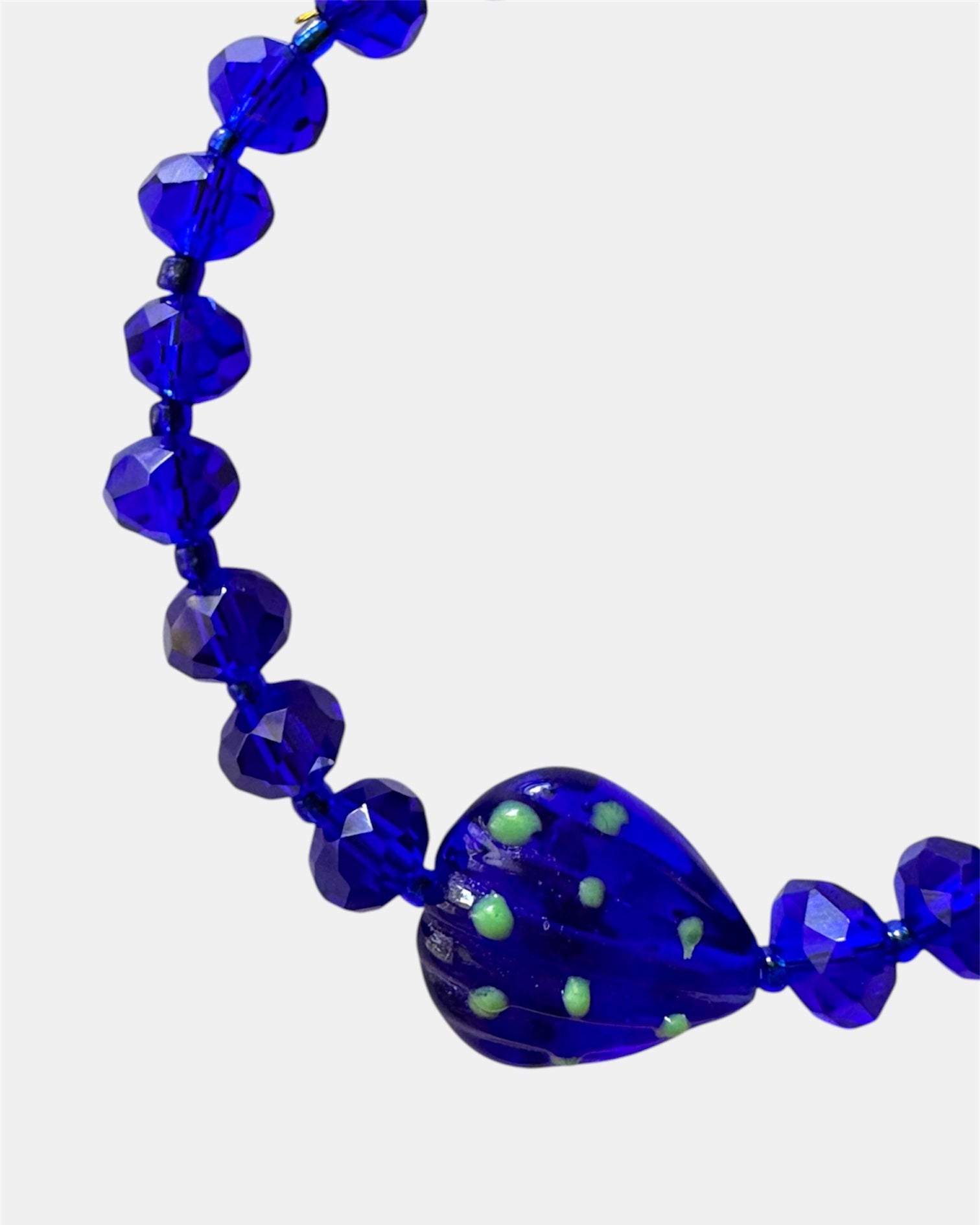 Blue bracelet decorated with glass beads and a small seashell charm for a beach-inspired look