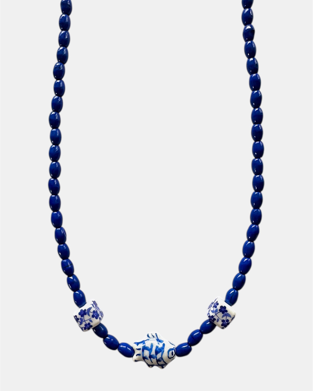 Blue beaded necklace with decorative elements on a white background