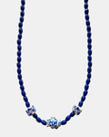 Blue beaded necklace with decorative elements on a white background
