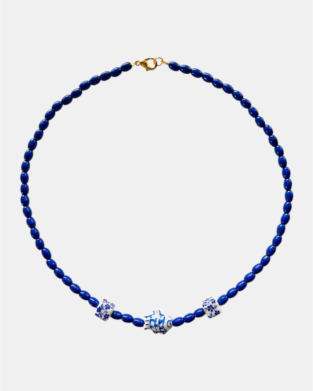 Blue beaded necklace with decorative elements on a white background