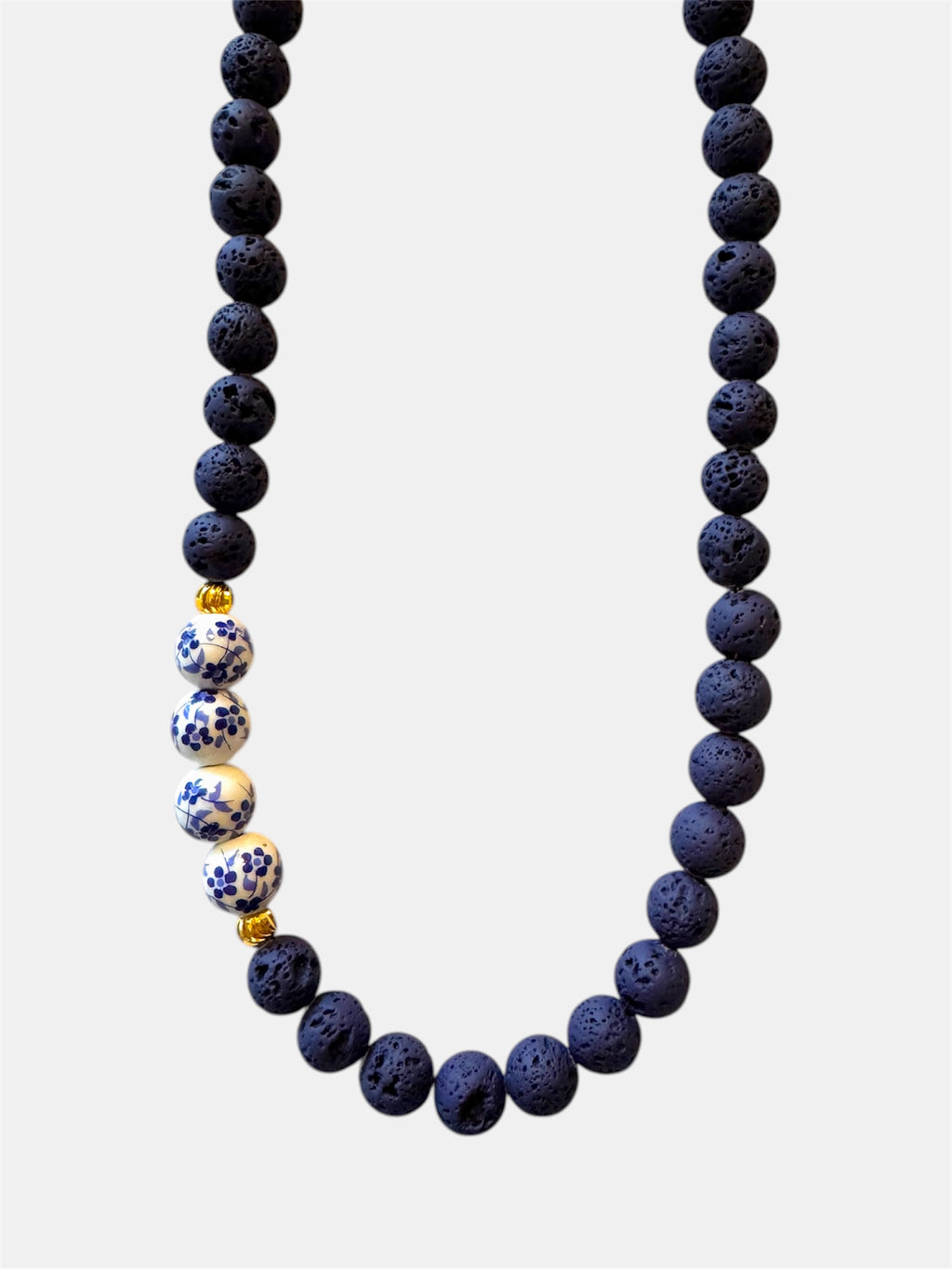 Blue necklace featuring lava beads and ceramic beads for a unique and textured style