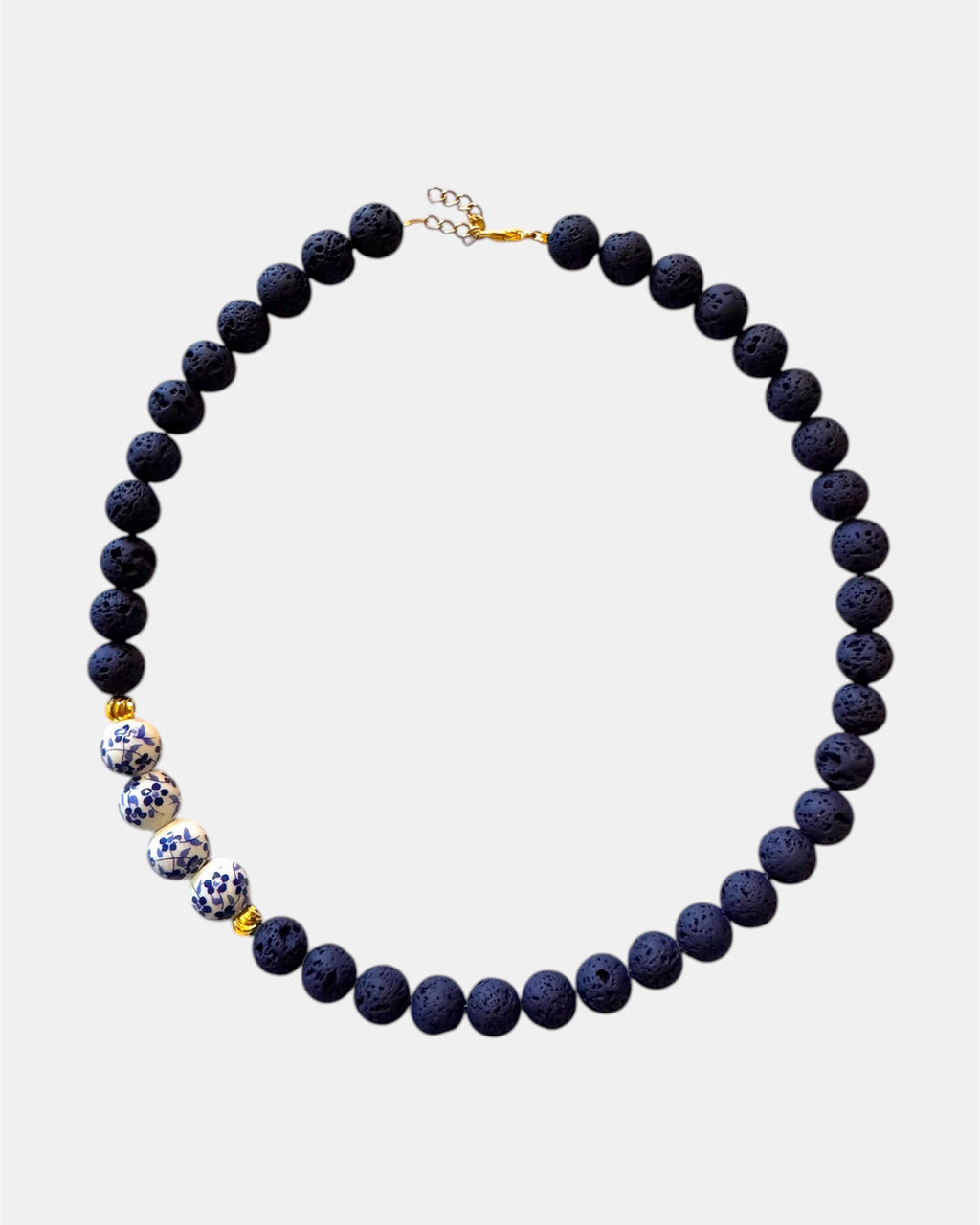 Blue necklace featuring lava beads and ceramic beads for a unique and textured style