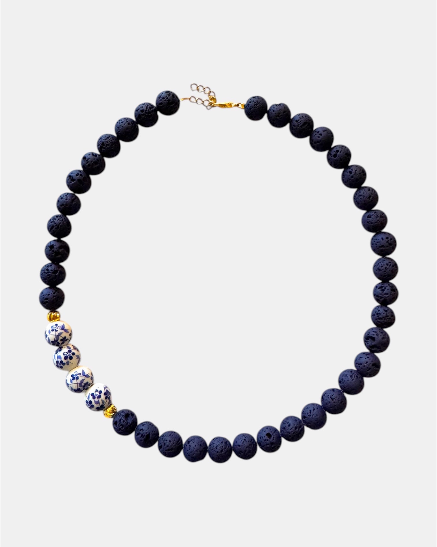Blue necklace featuring lava beads and ceramic beads for a unique and textured style