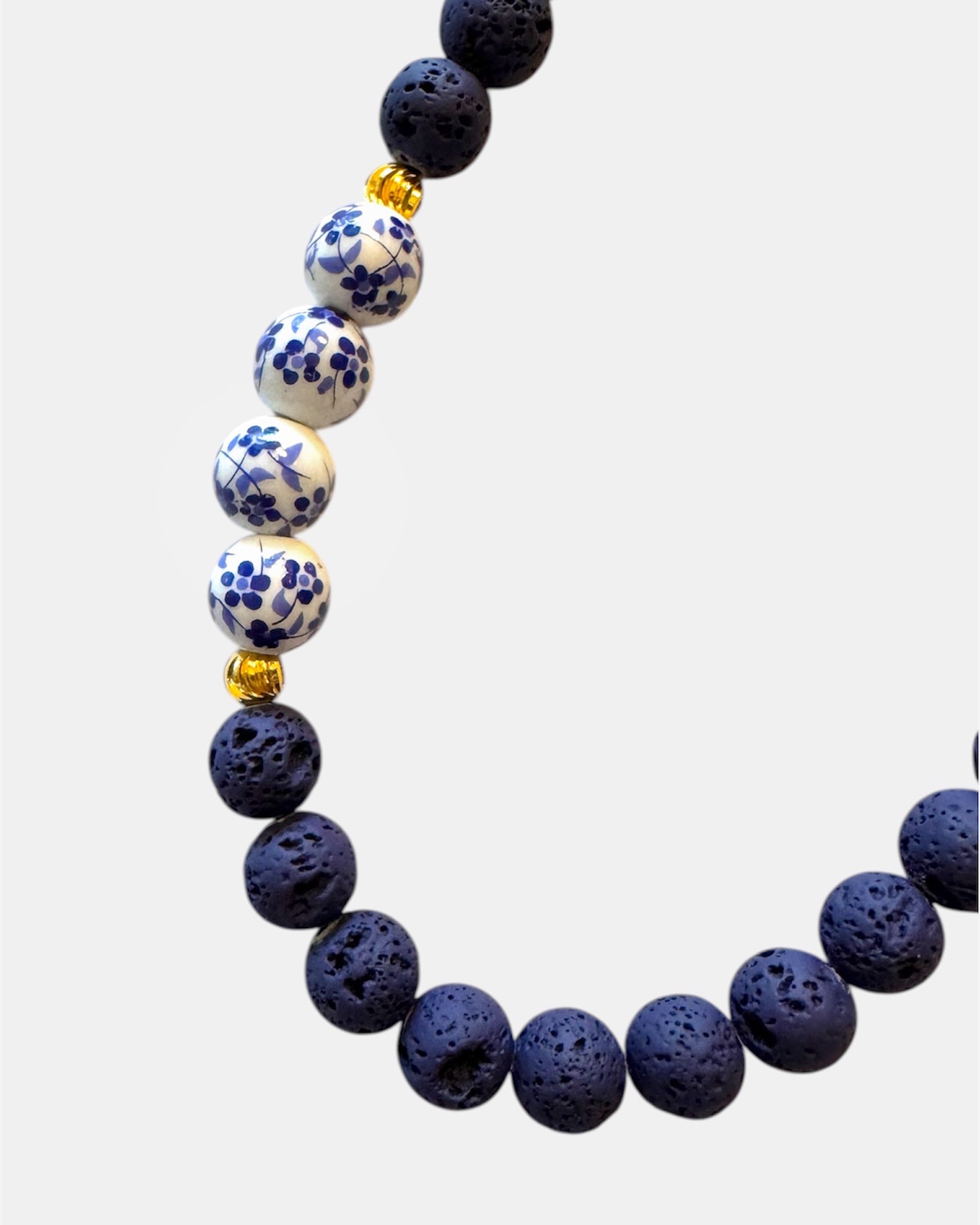 Blue necklace featuring lava beads and ceramic beads for a unique and textured style