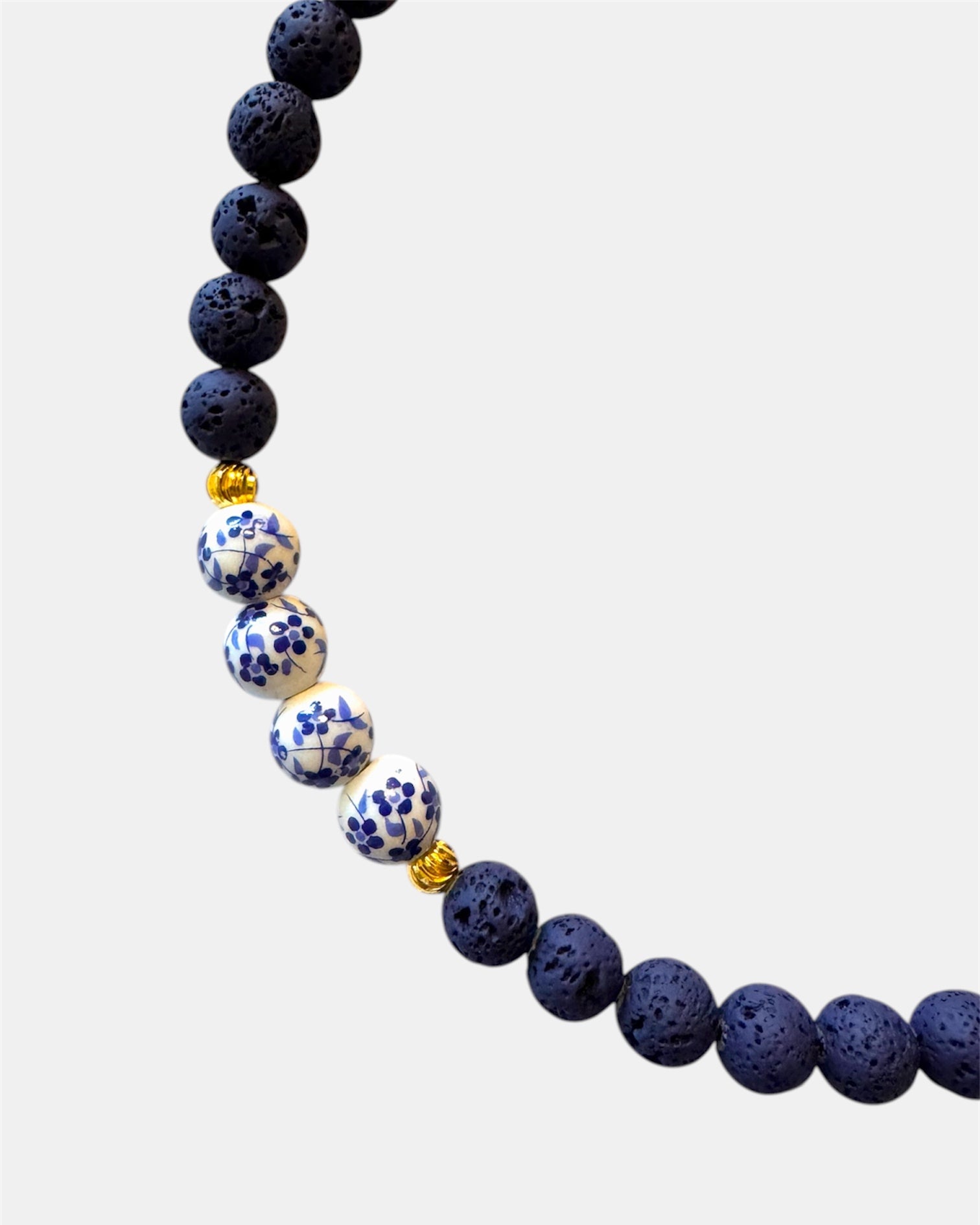 Blue necklace featuring lava beads and ceramic beads for a unique and textured style