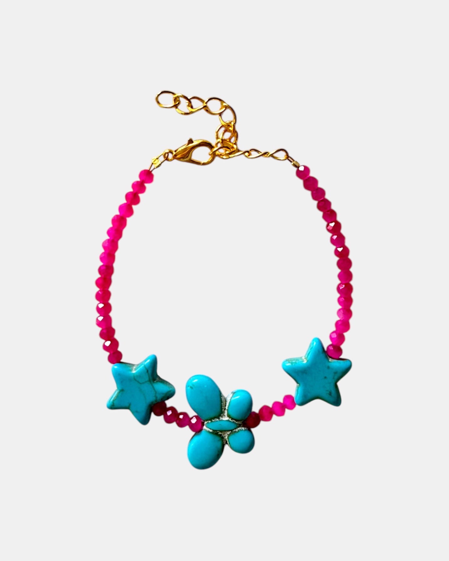 Fuchsia bracelet decorated with turquoise star charms and a butterfly for a whimsical, playful style