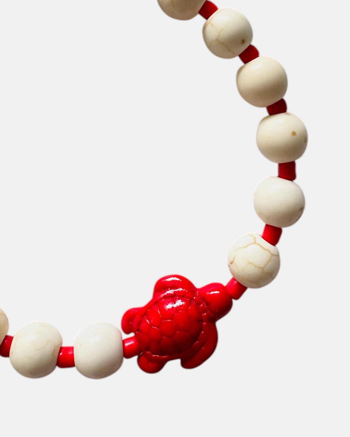 Elegant gold bracelet with ecru beads and ceramic turtle charm, handmade jewelry with natural tones inspired by the sea and coastal lifestyle