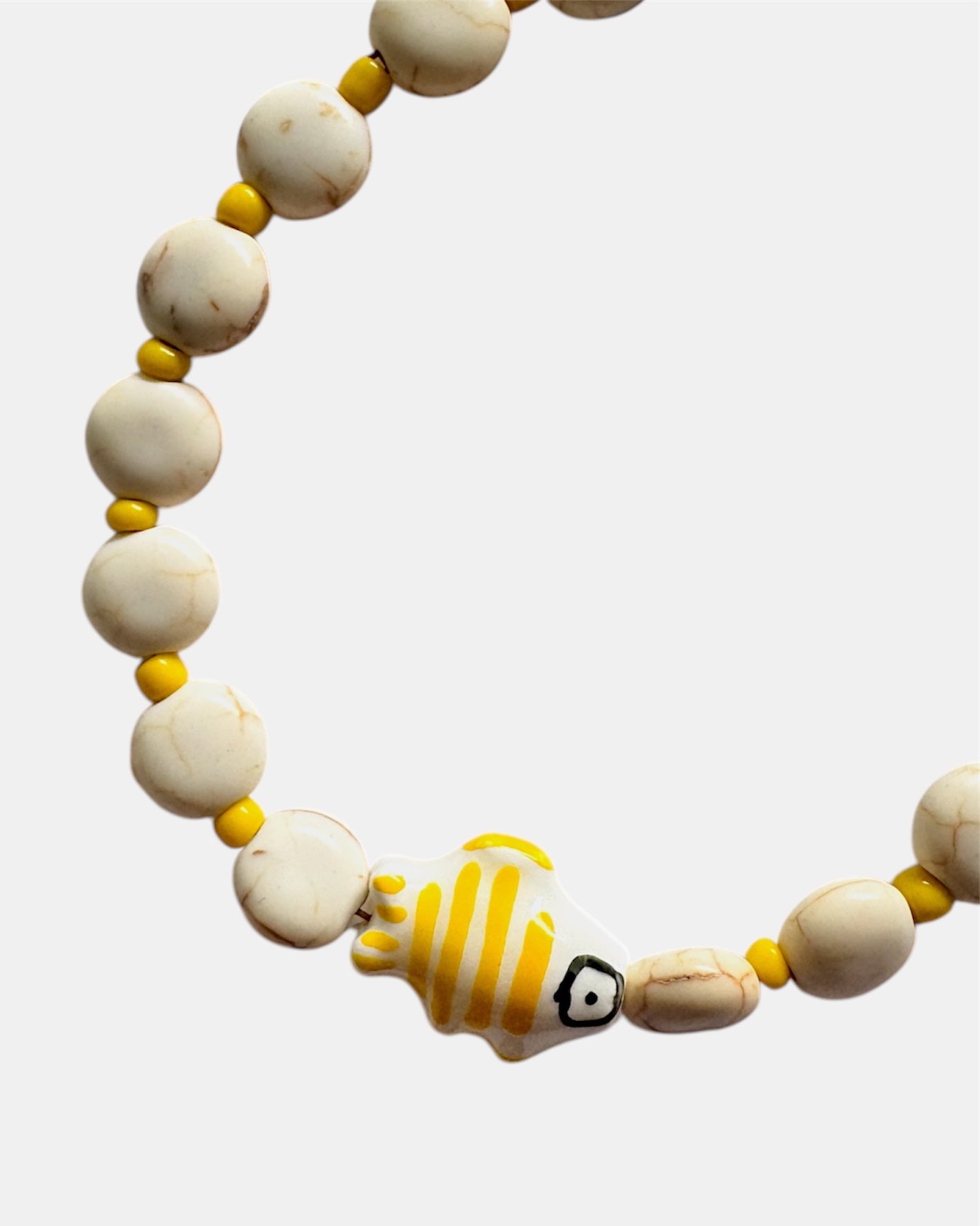 Elegant gold bracelet with ecru beads and fish charm, minimalist handmade jewelry inspired by the sea and coastal style
