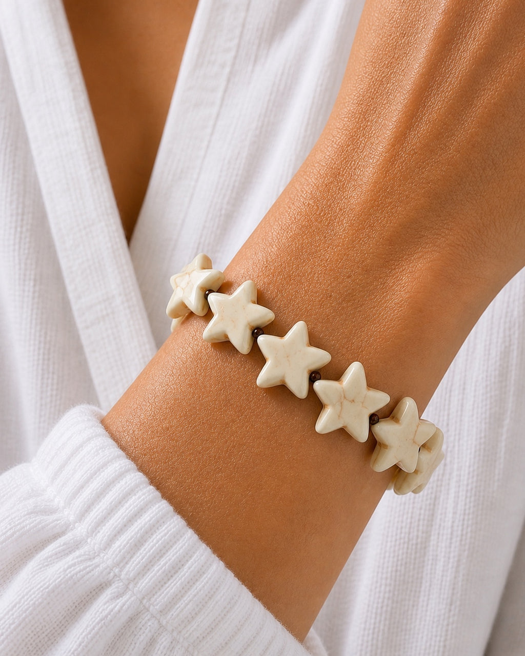 Gold bracelet with ecru star charms.