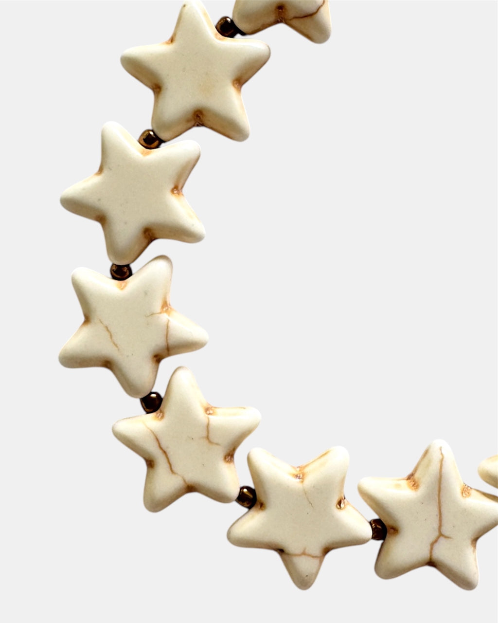 Gold bracelet with ecru star charms.