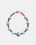 Gold bracelet with mint and fuchsia beads.