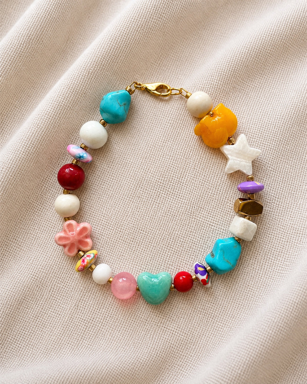Gold bracelet featuring multiple multicolored beads arranged along a fine chain, creating a vibrant and elegant jewelry design.