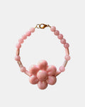 Gold bracelet with pink beads and a ceramic flower charm