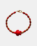 Elegant gold bracelet with red glass beads and ceramic turtle charm, stylish handmade jewelry inspired by nature and coastal design