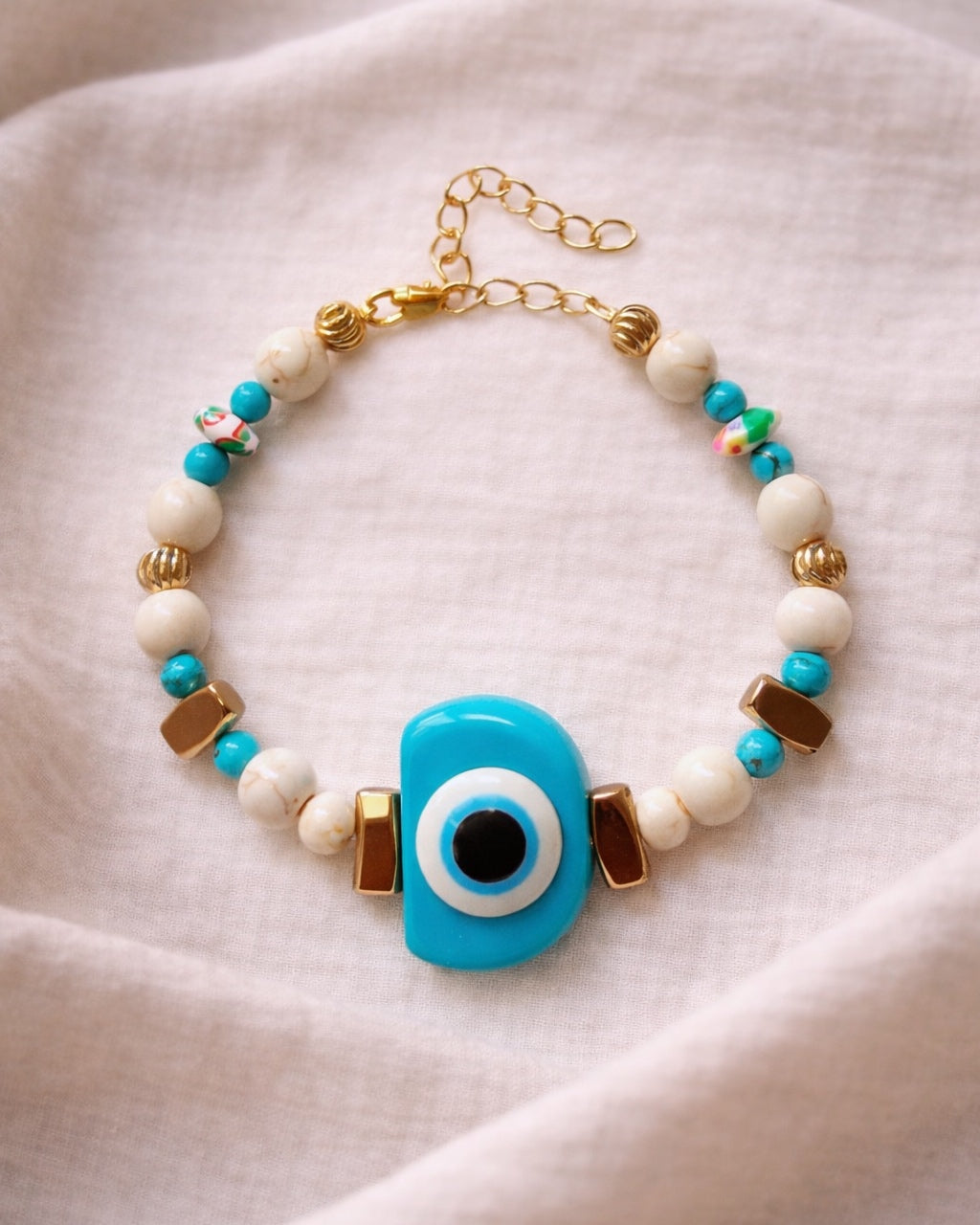 Gold bracelet with turquoise eye and ecru beads