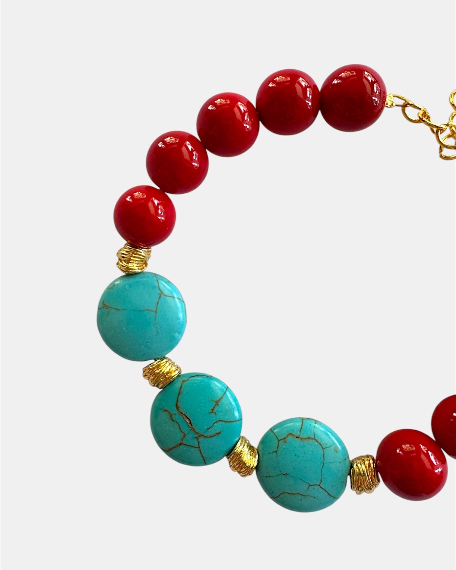 Gold bracelet with red and turquoise beads in colorful elegant style