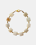 Bracelet with square-shaped cream beads on a gold chain against a white background