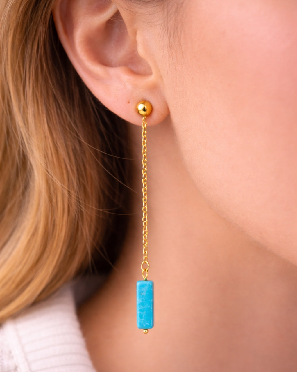 Gold dangle earrings with a blue stone