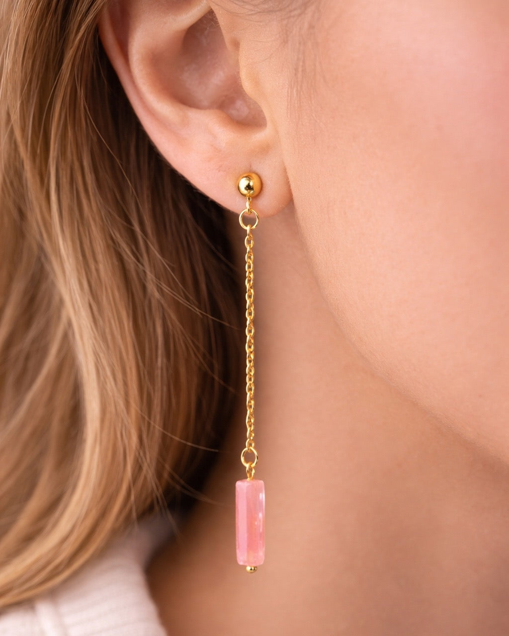 Gold dangle earrings with a pink stone