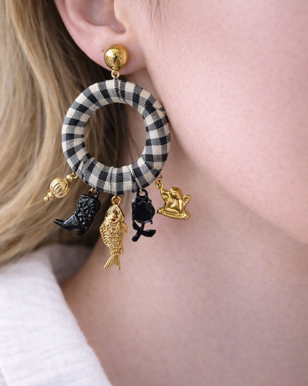 Gold dangling earrings with checkered hoop and charms.