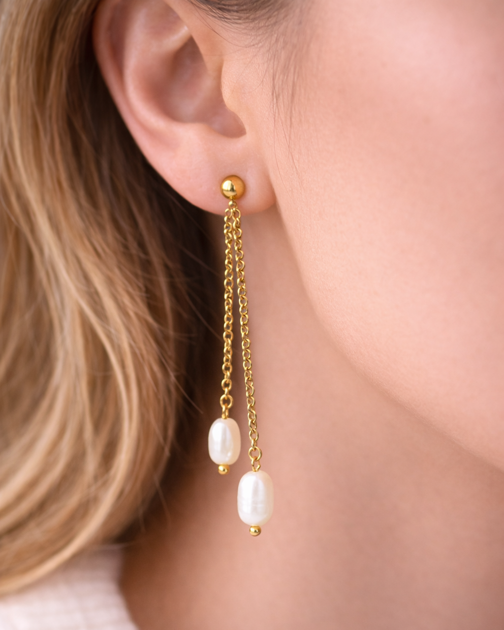 Gold dangling earrings with pearl.