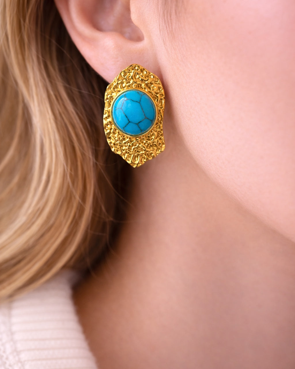 Gold dangling earrings with teal stone.