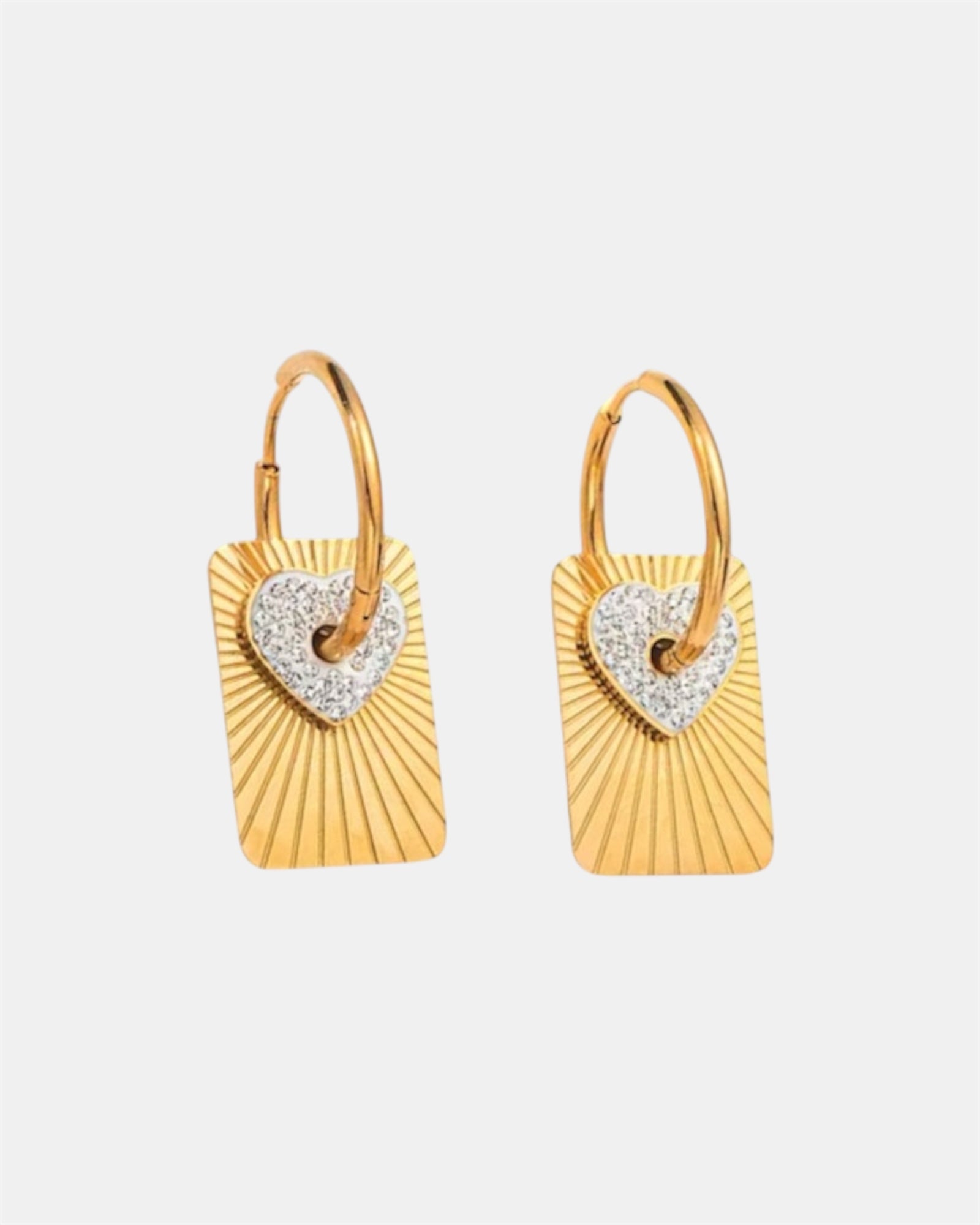Gold hoop earrings with heart pendant and flat medallion.