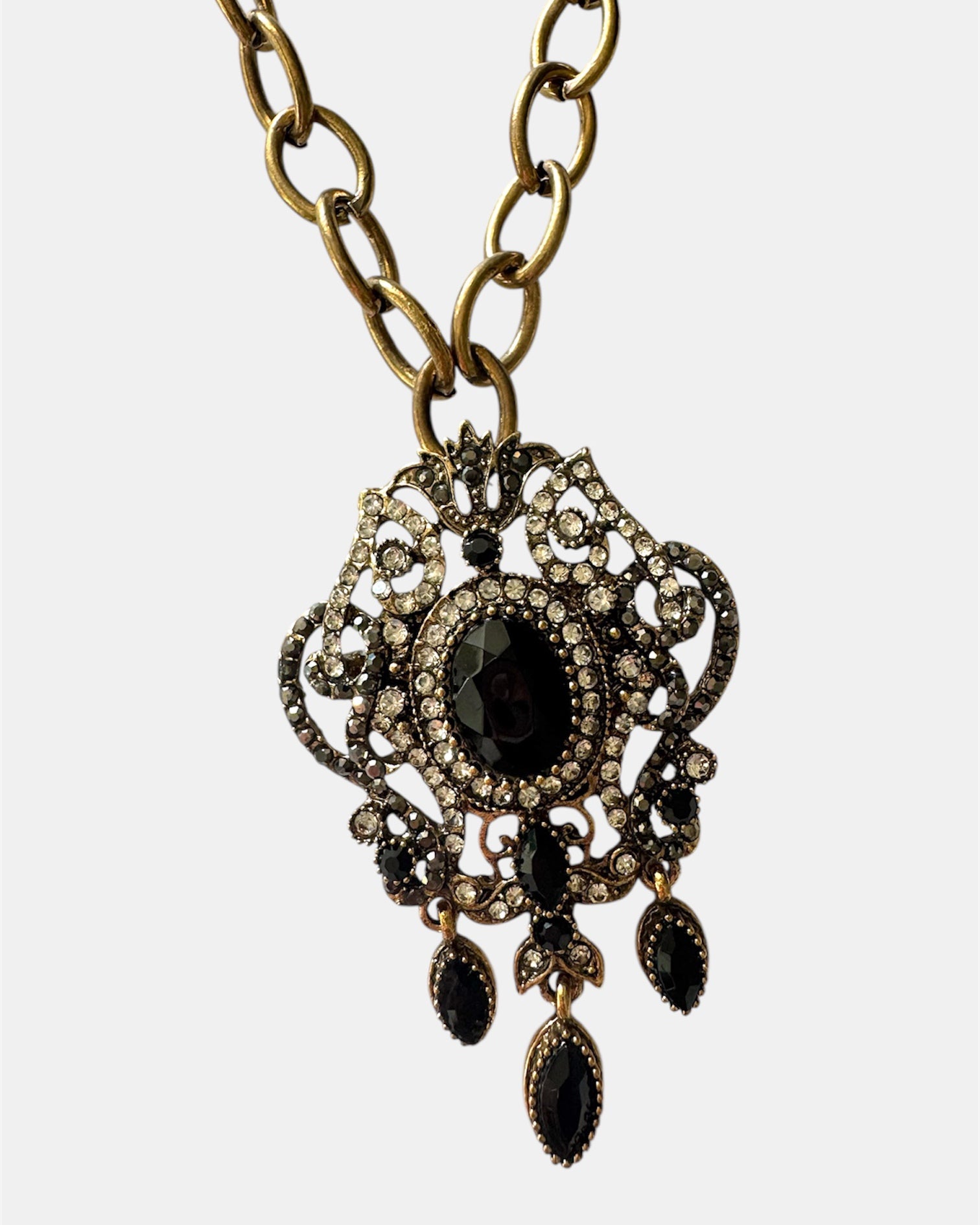 Gold necklace with a black vintage pendant