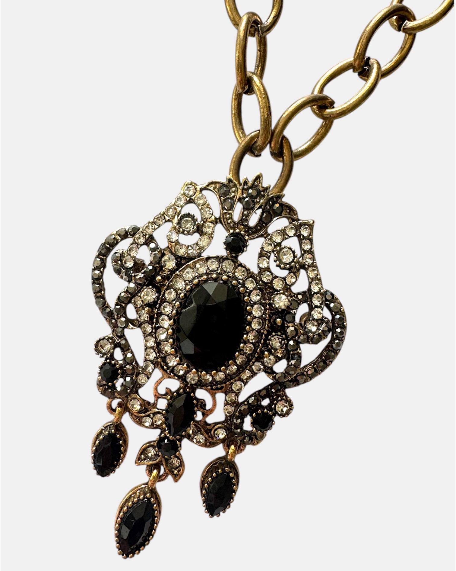 Gold necklace with a black vintage pendant