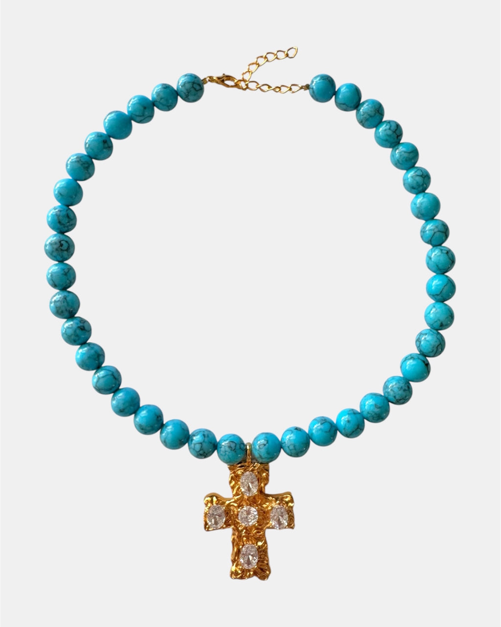 Gold necklace with turquoise beads and a cross pendant.