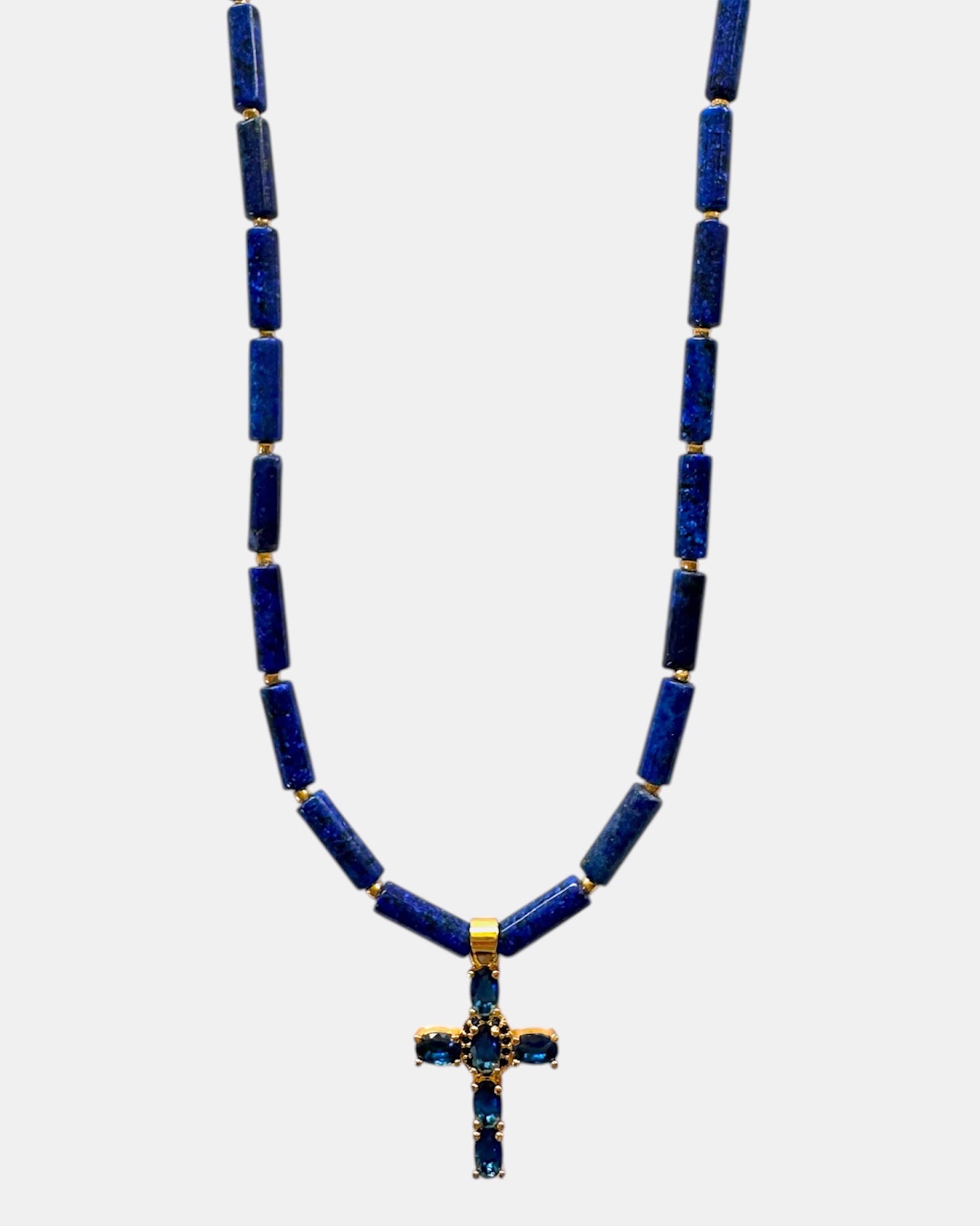Necklace with blue beads and a cross pendant on a white background