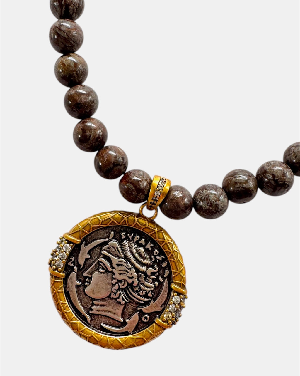 Necklace with brown beads and a decorative pendant on a white background
