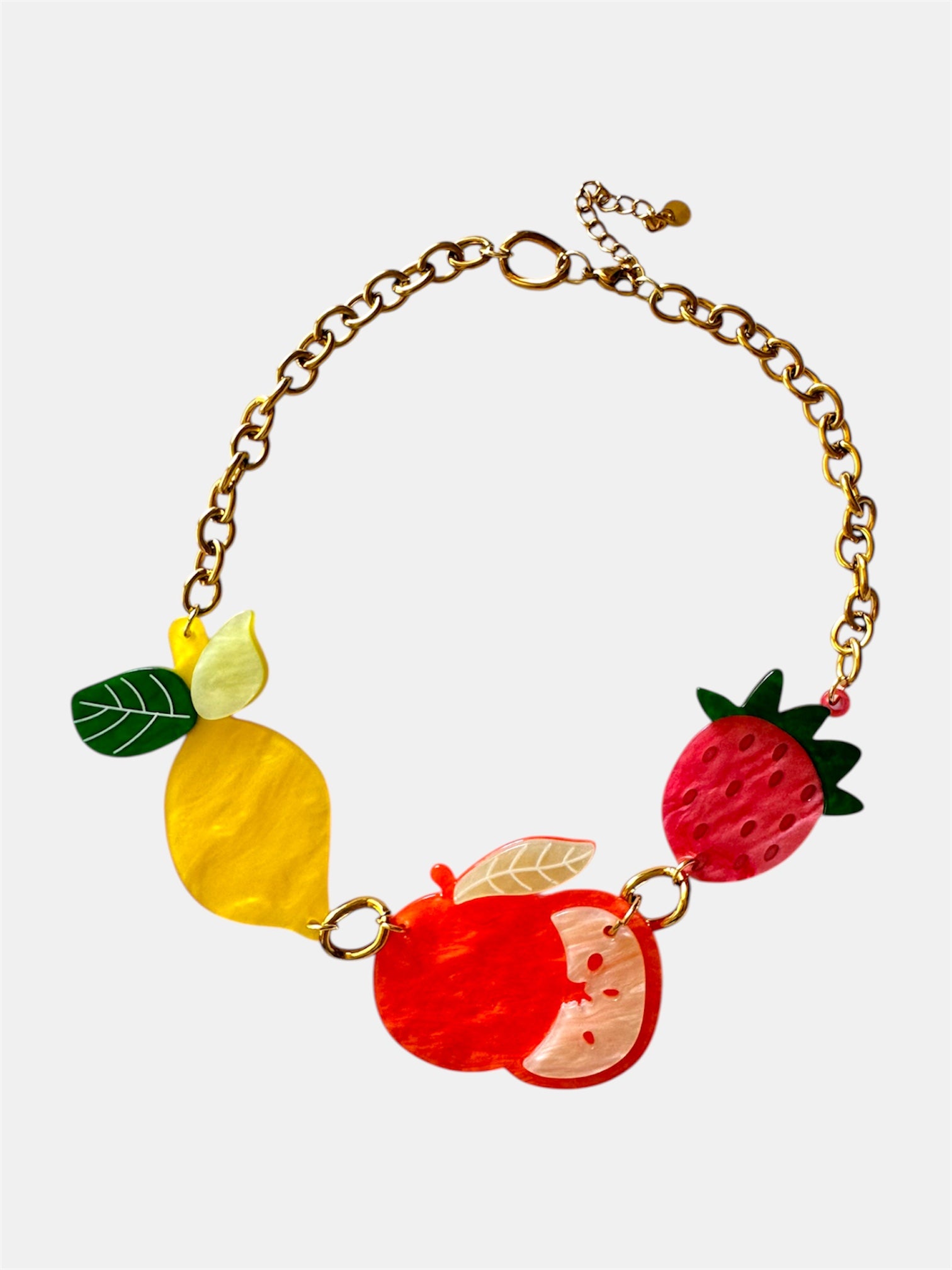 Gold necklace featuring small fruit-shaped charms for a playful and stylish look