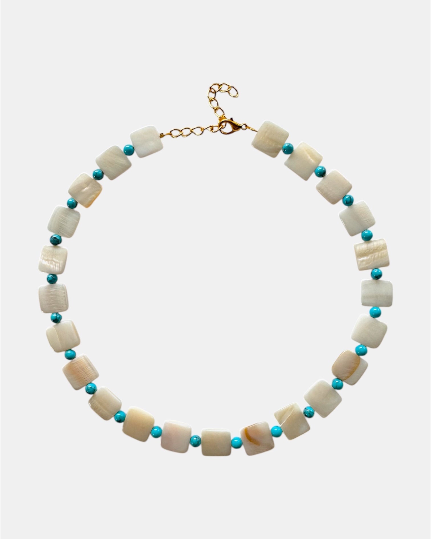 Necklace with white beads and turquoise accents on a white background