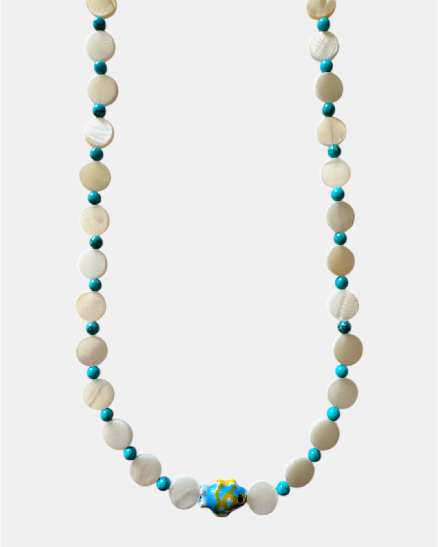 Necklace with white and blue beads on a white background