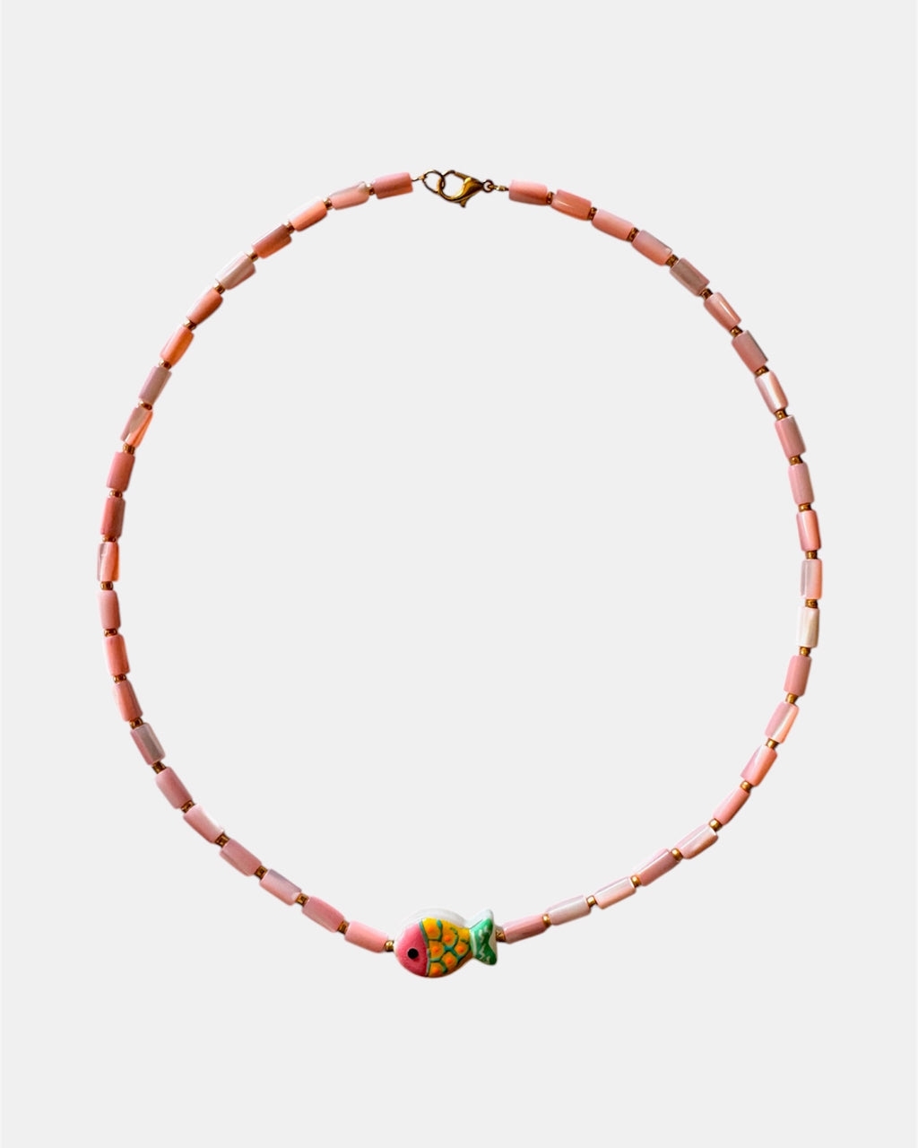 Necklace with pink beads and a colorful fish charm on a white background