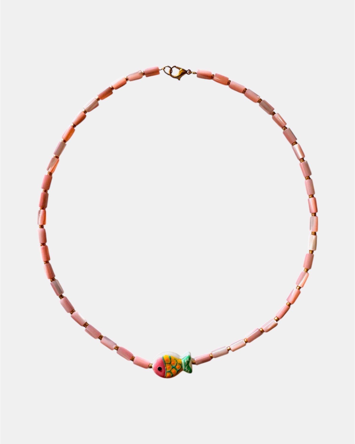 Necklace with pink beads and a colorful fish charm on a white background