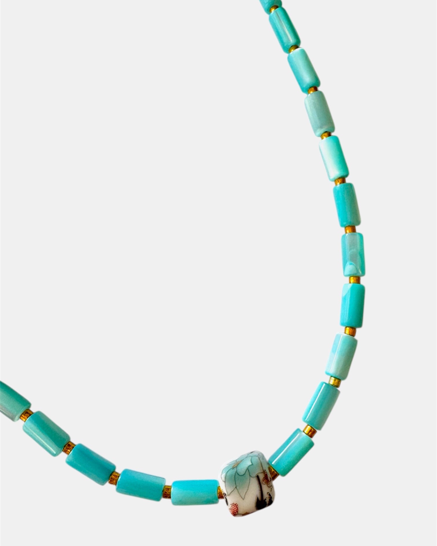Turquoise beaded necklace on a white background