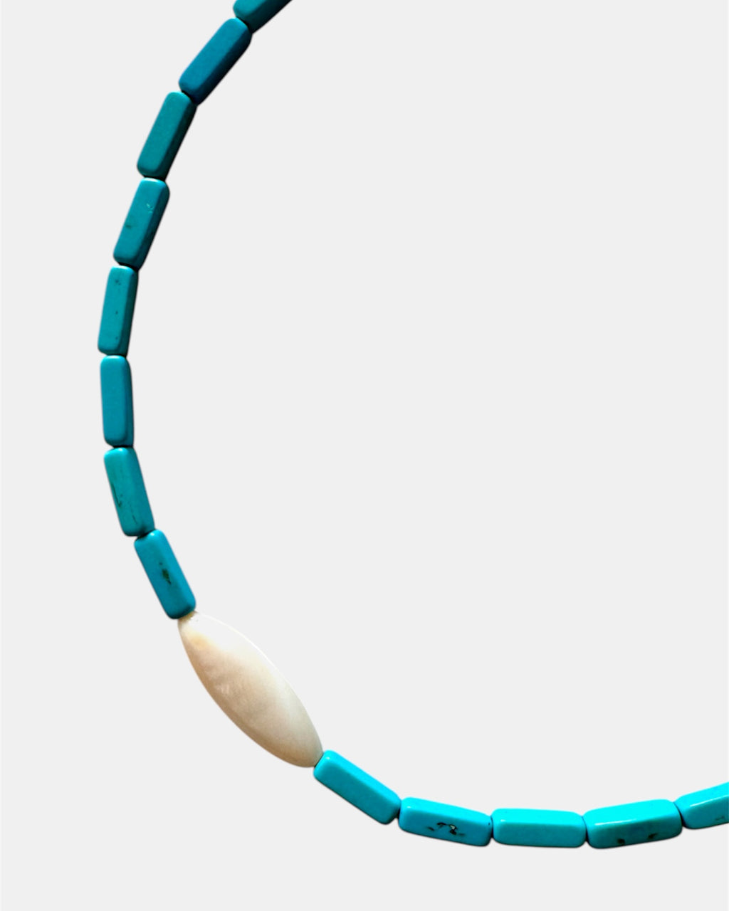 Necklace with blue beads and a central beige bead on a light gray background