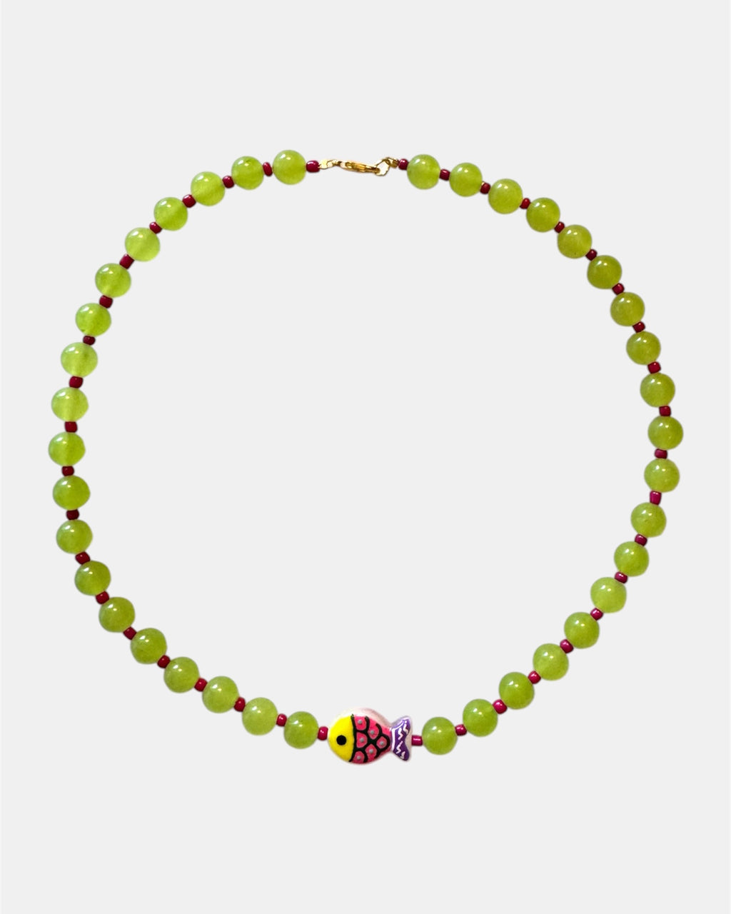 Green beaded necklace featuring a small fish charm for a playful and ocean-inspired style