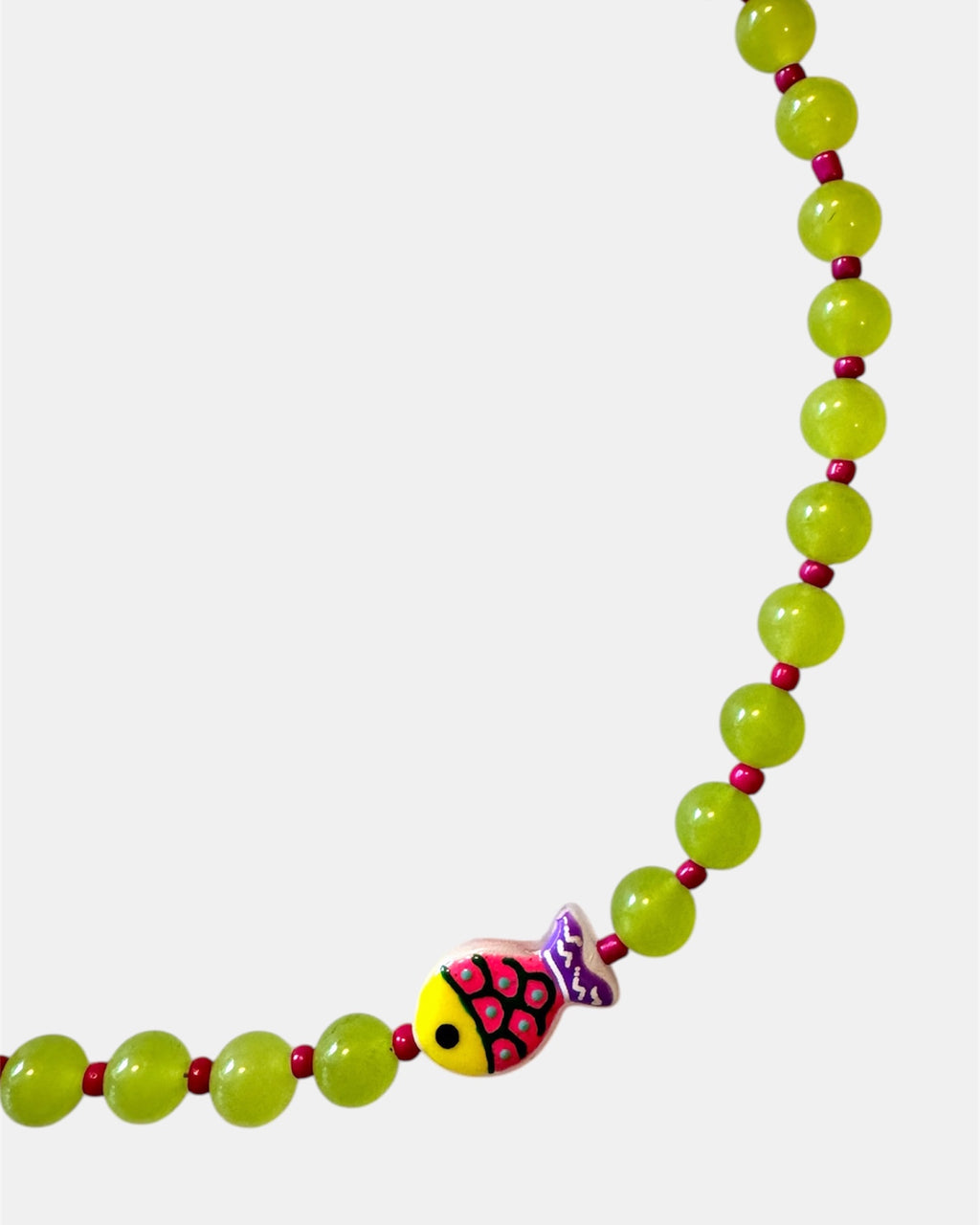 Green beaded necklace featuring a small fish charm for a playful and ocean-inspired style