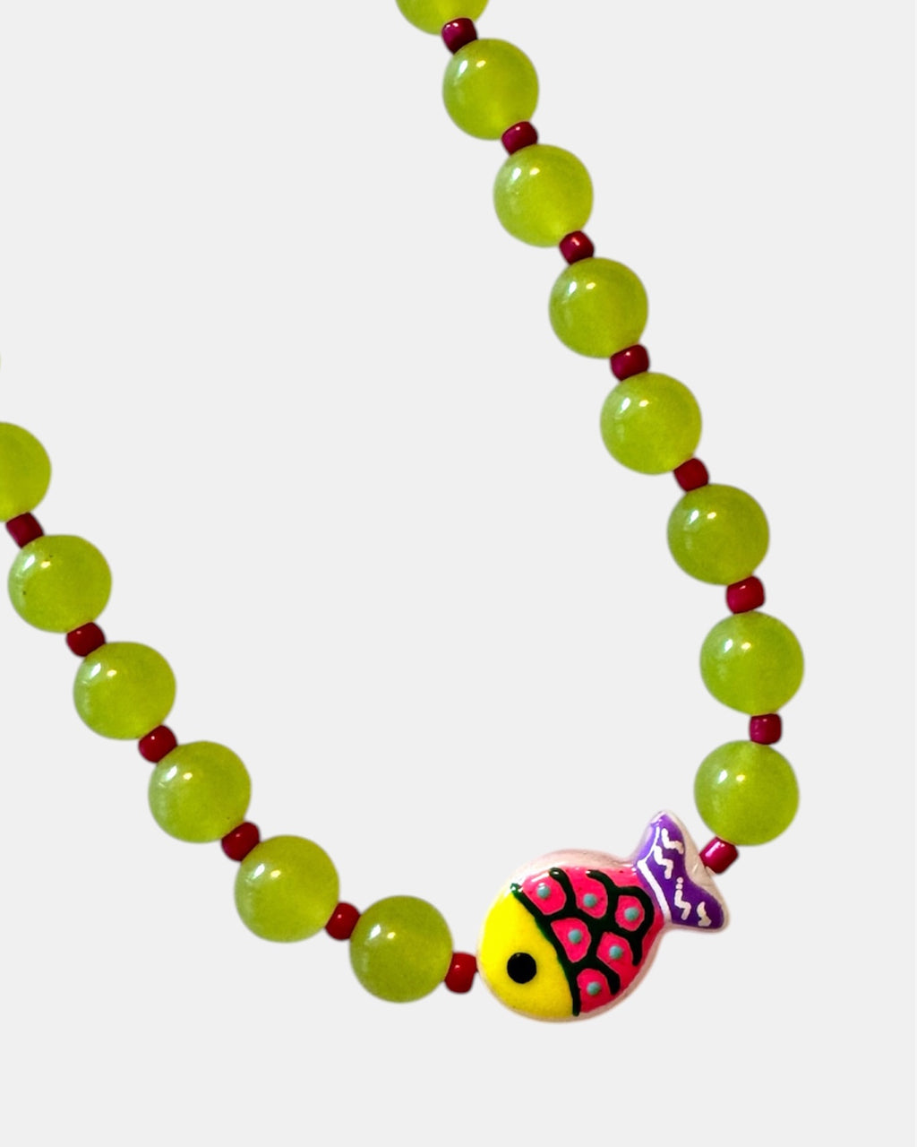 Green beaded necklace featuring a small fish charm for a playful and ocean-inspired style